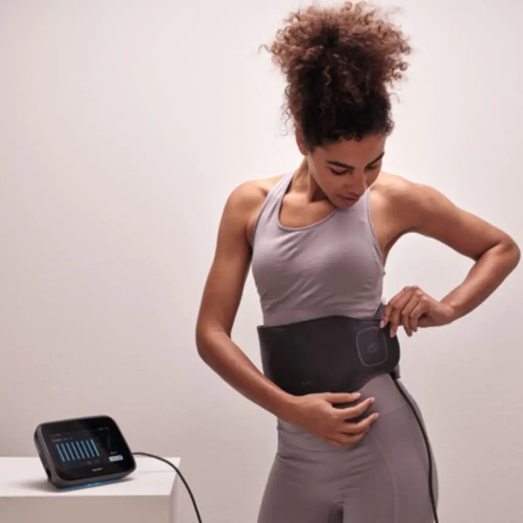 Woman wearing a BEMER wearable device around her waist to support circulation, energy, and recovery at Haute Healing Oasis.